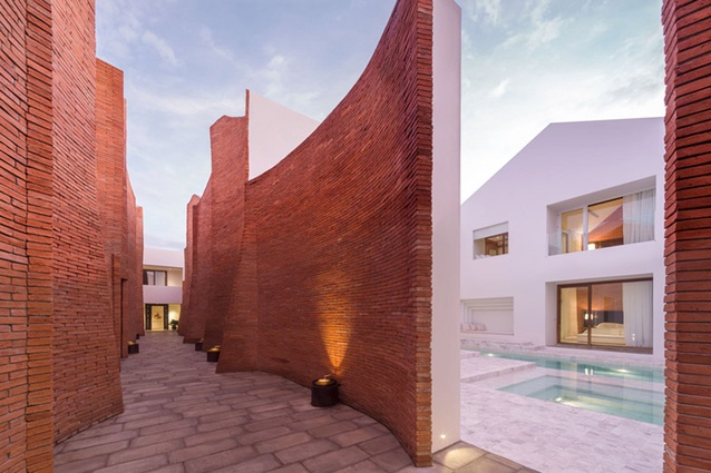 Sala Ayutthaya by Onion, Thailand. The passageways of this boutique hotel are made from scalloped tall red brick walls that mask views of the neighbouring temple and old city.