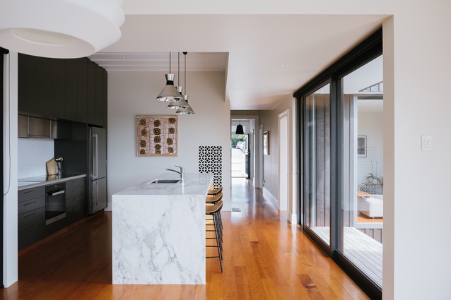 Recycled kauri floorboards cohesively merge the old and new areas of the house and were of a similar price to that of installing new floorboards.