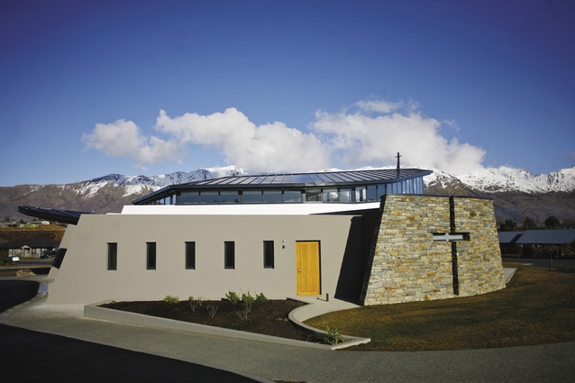 Framed by a dramatic mountain backdrop, the north-east elevation features a cruciform wall.