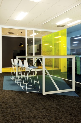 Blue, orange, and yellow, the Roche brand colours, predominate through the workplace meeting rooms and informal break-out spaces.