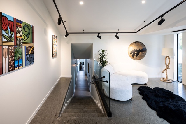 With white walls and ceiling and a concrete floor, the entrance foyer is akin to an art gallery. 