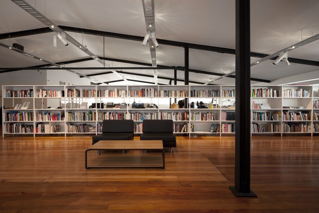 Library view – interlocking bookshelves neatly separate the office’s gallery space from its workstations.