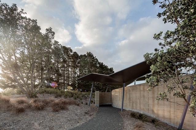 A loose-metal path leads you round the side of the building and through the curved, rammed-earth entrance.