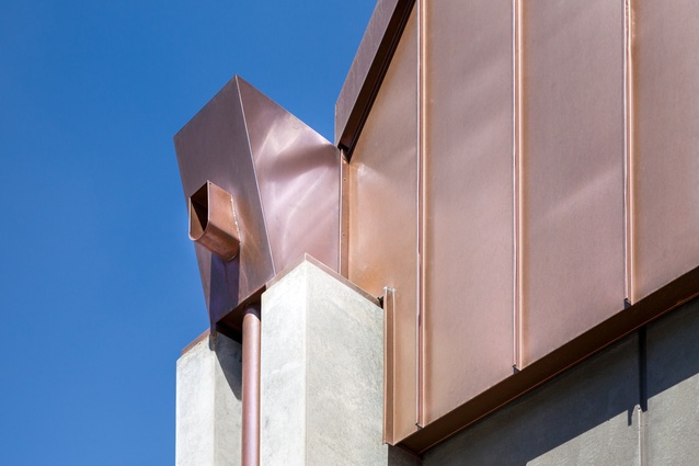 Copper cladding contrasts against the sturdy concrete buttresses.