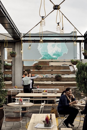A mural of Ralph Hotere provides an impressive artistic backdrop to the well-planted outdoor area.
