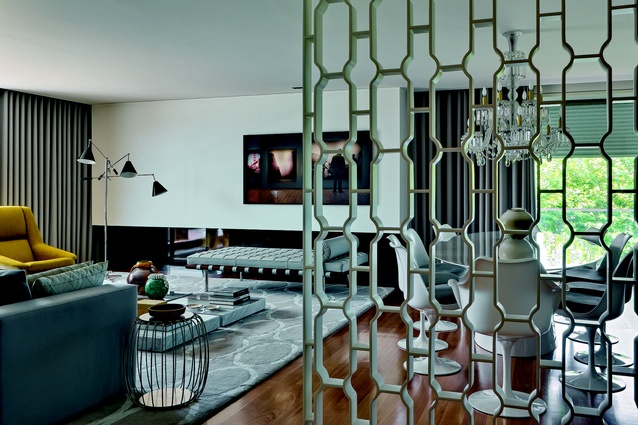 A lacquered iron screen by Cristina Jorge de Carvalho separates the entrance and living spaces.
