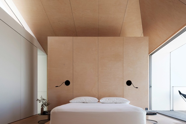 The main bedroom enjoys ocean views and has a ceiling that folds up like an origami ply-clad vault.