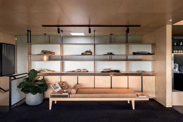 A handcrafted leather bench provides an informal waiting area in the SGA office. The plywood shelving was made on site and installed by the SGA team.