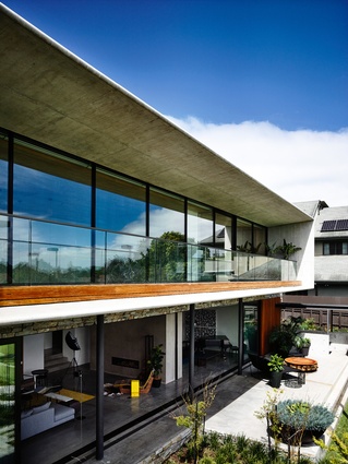 The rear of the home offers a verandah on the concrete-framed upper level and a planted court below.