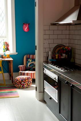 Brighouse painted the kitchen cabinets black and filled the room with colourful appliances and furniture. 