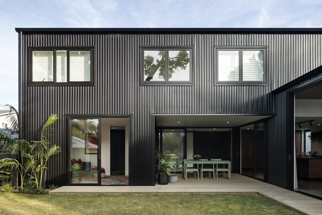 The house is clad in black metal, reminiscent of corrugated iron.