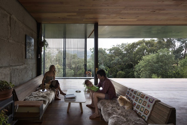 A custom timber screen and stacking doors partition the indoor and outdoor spaces. 