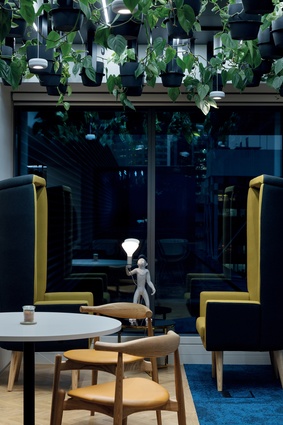 Hanging plants and quirky furniture pieces lighten the feel of the café space.
