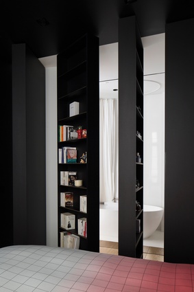 Rotating bookcases in the bedroom pivot to reveal the stark white bathroom.