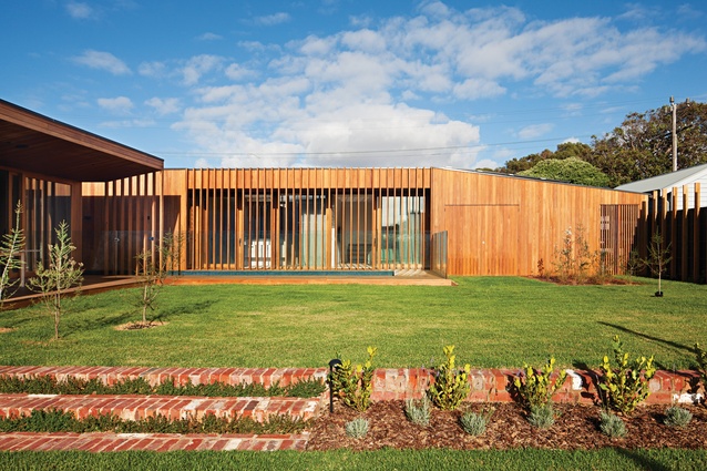 The house’s L-shaped plan forms a protective perimeter around a private lawn and garden.