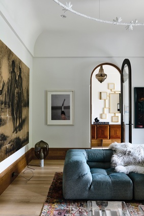 One wall of the sitting room hosts a gold-hued artwork, <em>Australia II Peace</em>, by Brook Andrew and facing it is <em>Breathless</em>, a print by Pat Brassington.