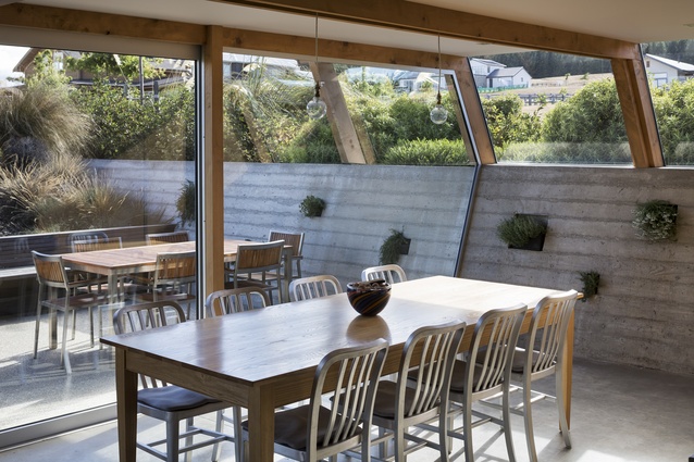 The dining room of Wanaka House. The in-situ concrete wall offers a practical thermal mass element to regulate temperatures.