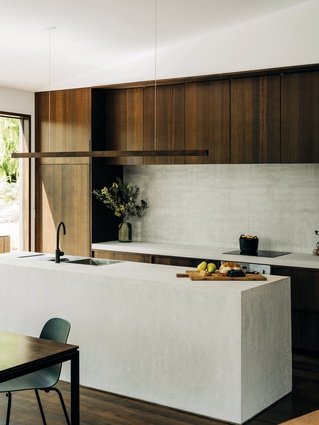 Concrete has been used as a contrasting, cost-effective and hardwearing material for the kitchen bench.