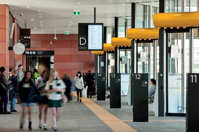 “Users gather in a central space with a number of bus bays arrayed in front of them with clear signage.”