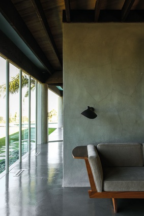 A George Nakashima sofa designed for Widdicomb fits well with the concrete tones in the walls and floor.