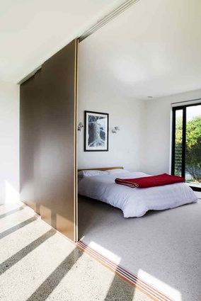 Large sliding doors let more light into this bedroom from the hallway. 