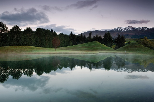 Sculpted around an artificial lake, undulating hills echo the distant snow-capped mountains.