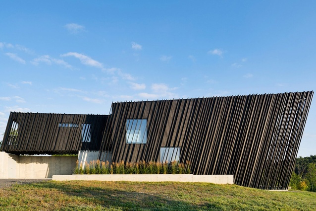 Sleeve House, Hudson Valley, United States, by Actual Office Architects. 2017. This slanted black holiday house presents as two elongated volumes, a smaller one sleeved into the larger.