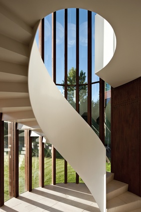 A staircase indoors, artful and curling, encapsulates the home’s undeniable sense of drama. 