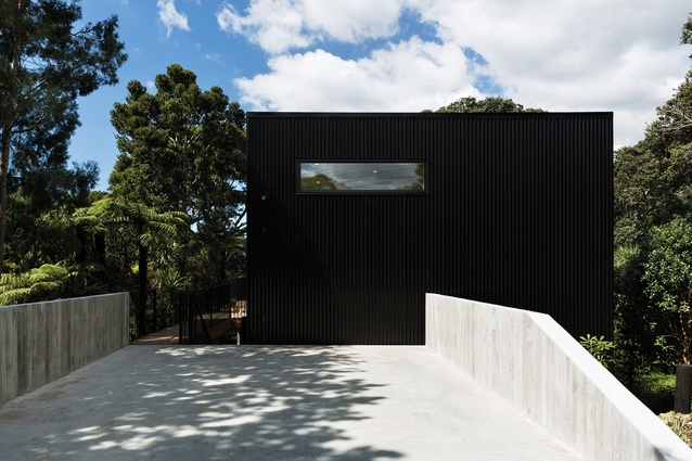 The roadside elevation of the two-storeyed home is very visible from a distance so it is purposefully stark and black.