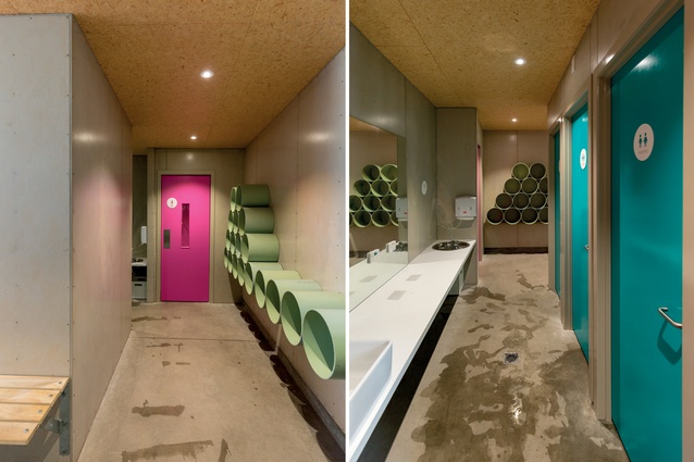 A simple palette of materials is utilised in the changing rooms, stylishly accented by turquoise and hot-pink doors and by pale-sage-green tubes which act as cubby holes.