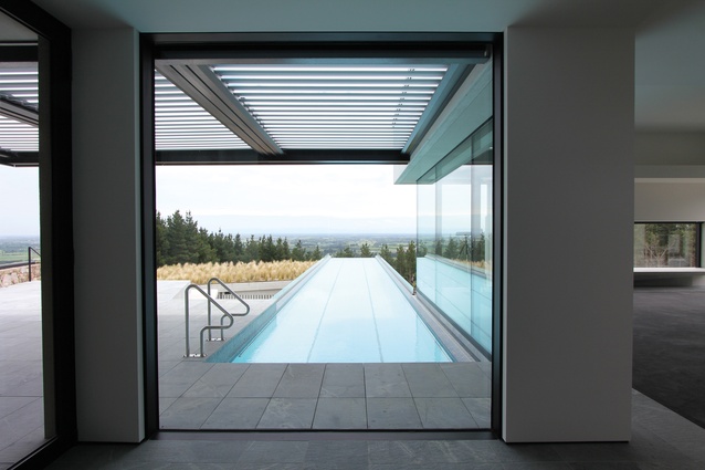 Aker Wood House: An infinity pool stretches out towards the planted roof of the pavilion below.