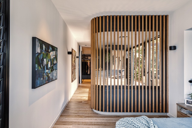 The en suite is enclosed by a timber screen and looks out to a private side garden.