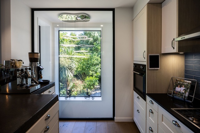The kitchen features a floor-to-ceiling window that connects to the stairwell and out to the view beyond.