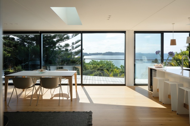 The north-west-facing open-plan kitchen, dining and living space looks out over Waiheke’s Onetangi Beach. Floating Table and Bai Chairs from Tim Webber Design.