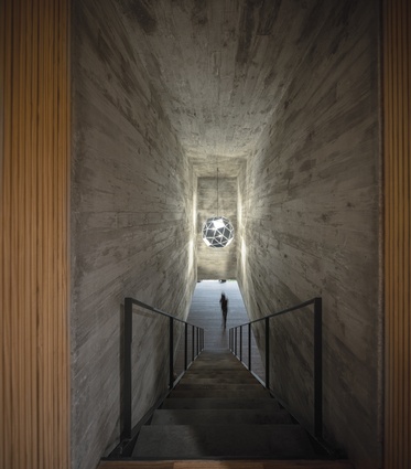 A reflective sculptural light fitting by Olafur Eliasson illuminates the entrance stairway.  