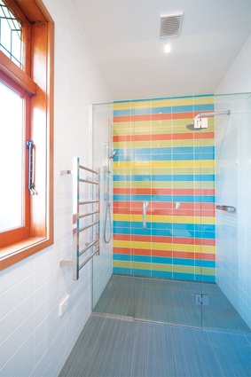 Floor to ceiling tiles impart a crisp – and decidedly colourful – look in the ensuite. 