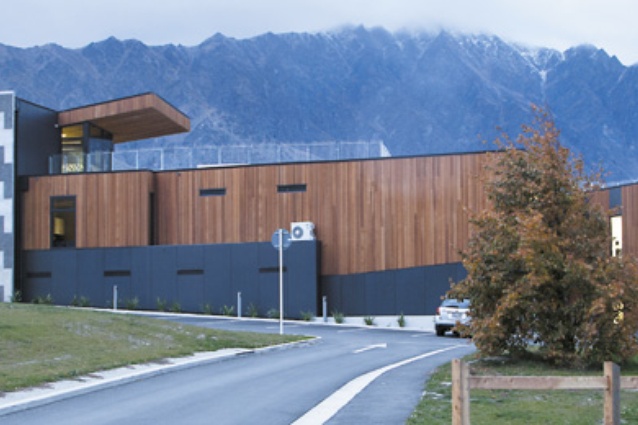 The western facade of the administration building, with learning pods at right. Exterior surfaces combine cedar cladding and fibre cement panels.