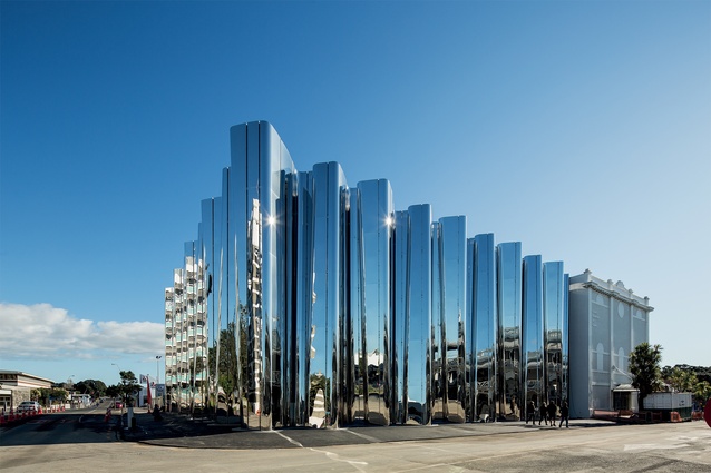 The new building links to the existing Govett-Brewster. The two street-facing façades consists of nine 14m-high concrete columns clad in highly polished stainless steel. 
