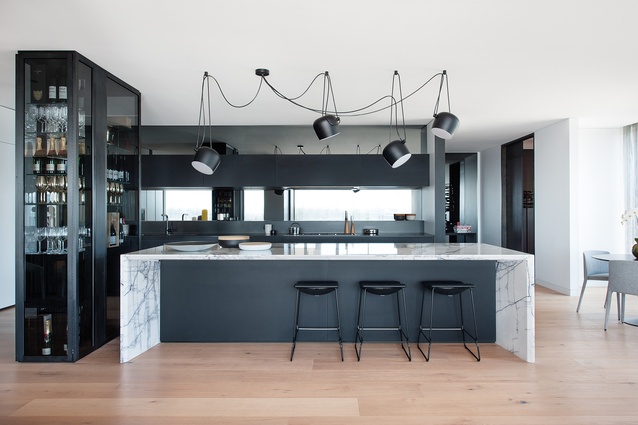 This dramatic kitchen retains a strong utilitarian presence, while still being connected to the penthouse’s other areas.
