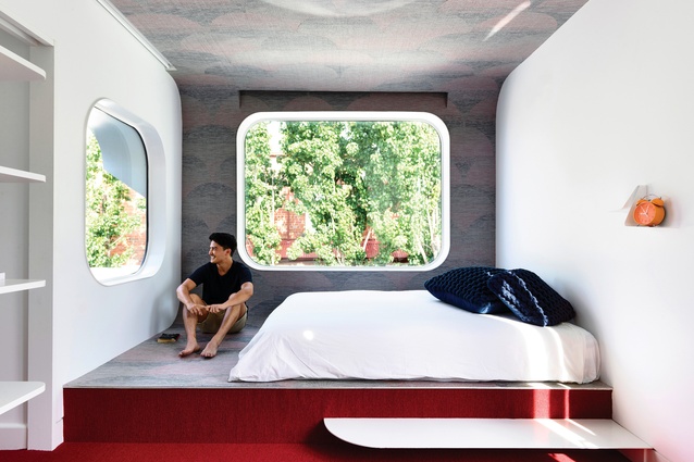 A cantilevered bedroom with distinctive round windows pops out over the title line, announcing itself to the street.