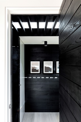 A monochromatic palette of black, rough-sawn cedar, pale timber and white surfaces is used throughout. Artwork: Tom Ferguson.