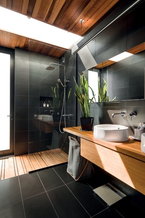 The main bathroom has a muted natural palette of materials. An external door will connect to a pool area when completed.

