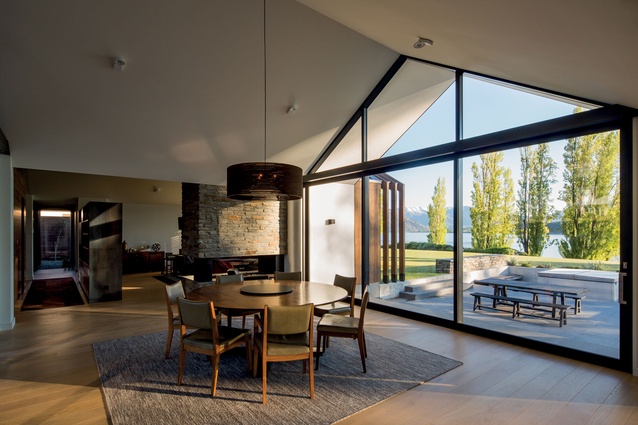 An Otago schist fireplace separates the dining and living zones.
