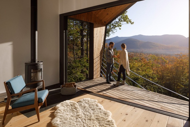 I-Kanda created 84-square-metre weekend residence Cabin on a Rock in New Hampshire, United States. A timber porch cantilevers out over a slope while a wood-burning fireplace keeps the home warm.