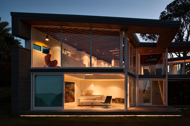 Daniel Marshall's Mellons Bay House glowing in the dusk.