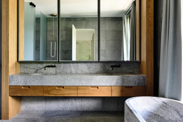 A free-standing stone bath and heavy set stone vanity with sculpted basins give the master en suite a Japanese aesthetic.