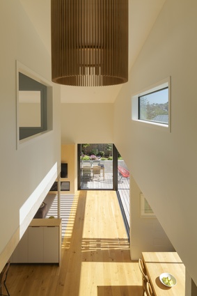A  window in the double height space allows for a view through from the mezzanine to the outdoors.