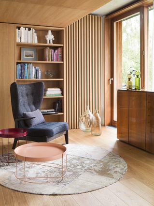 Pale, honey-coloured timber envelops this apartment, with texture provided through panelling and in-built shelving.