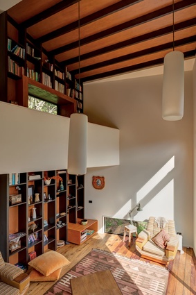 Floor-to-ceiling bookshelves extend to become the exposed rafters.
