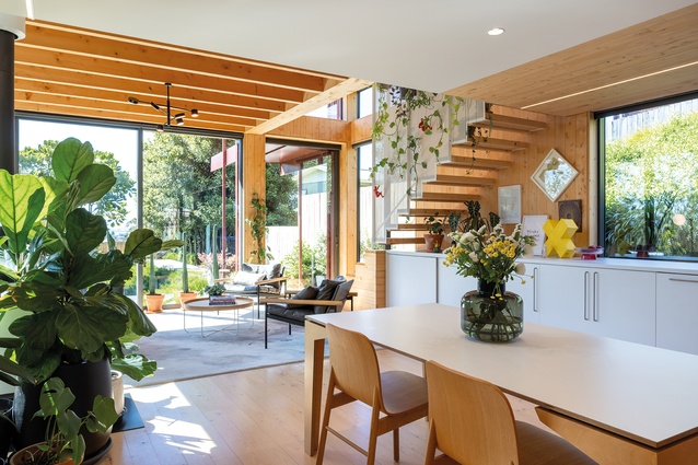 The dining space has view shafts to the garden and patio. The perforated screen of the floating stair can be seen to the right.